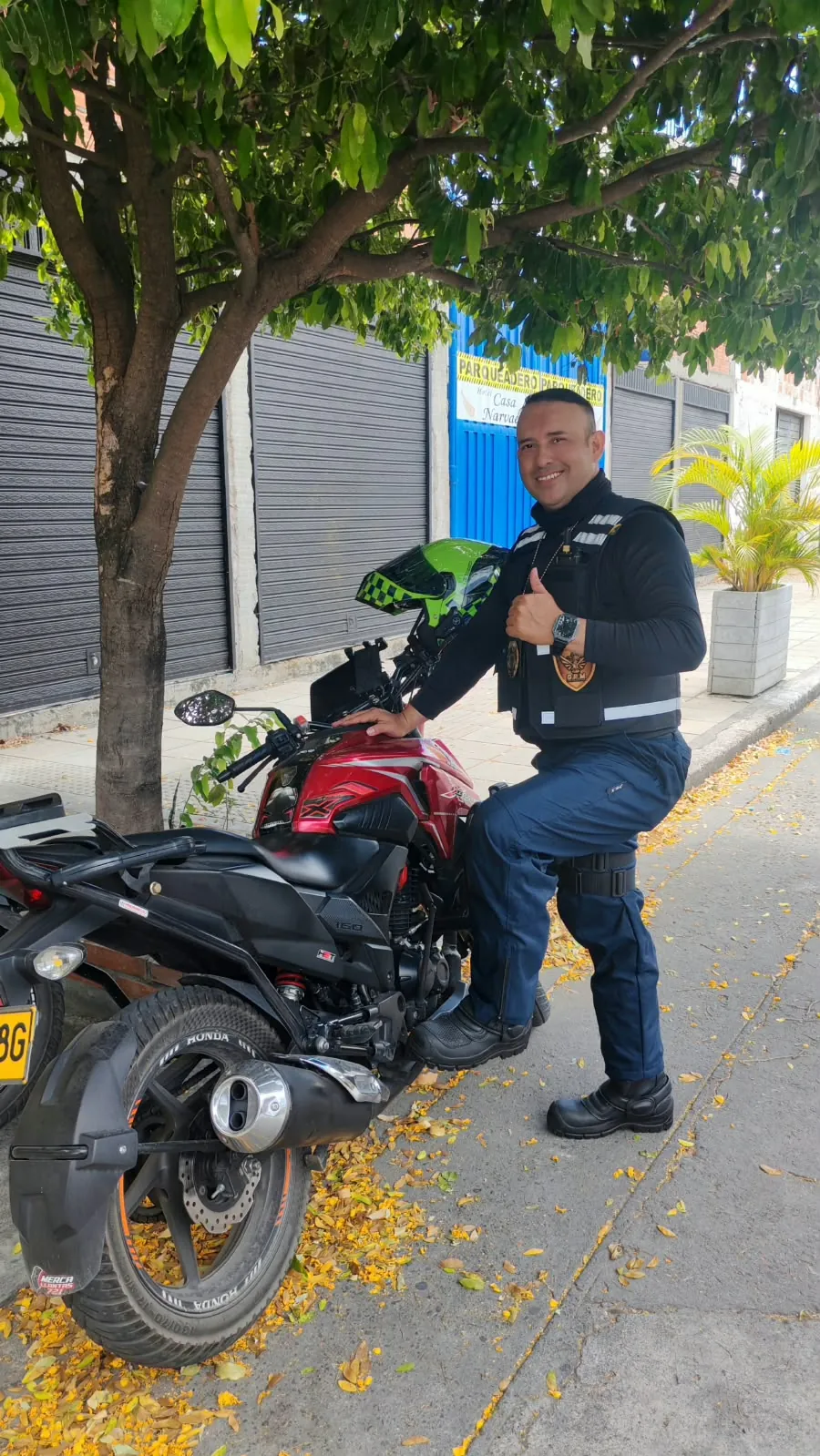 Integrante de GRM sobre una moto roja en la calle